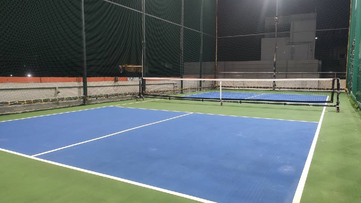 Blue and green pickleball court under lights